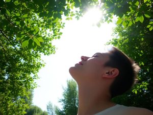 Persoană inspirând aer curat în natură.